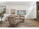 Staged living room with a stone fireplace, large window, and comfortable seating arrangement at 2492 S Yarrow St, Lakewood, CO 80227