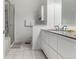 Bright bathroom featuring white tiled floors, double sinks, and a walk-in shower at 19 S Harrison St, Denver, CO 80209