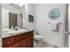 Bright bathroom featuring granite counters, round window, and neutral color scheme at 19 S Harrison St, Denver, CO 80209