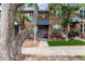 Attractive brick townhome featuring a blue front door, complemented by mature trees and a landscaped yard at 19 S Harrison St, Denver, CO 80209
