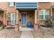 Charming brick townhome exterior featuring a blue front door and cozy porch seating at 19 S Harrison St, Denver, CO 80209