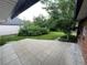 Secluded backyard featuring a stone patio, mature landscaping, a manicured lawn, and brick exterior at 701 S Clayton St, Denver, CO 80209