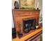 Cozy fireplace with wood mantel, brick surround, and decorative fireplace screen at 701 S Clayton St, Denver, CO 80209
