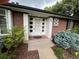 Charming brick home featuring a well-manicured garden and stylish, glass-accented front door at 701 S Clayton St, Denver, CO 80209