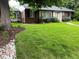Charming brick home with a well-manicured lawn, mature trees, and landscaping at 701 S Clayton St, Denver, CO 80209