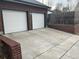 Two-car garage with large driveway and brick retaining wall at 701 S Clayton St, Denver, CO 80209