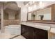 Luxurious bathroom with a soaking tub, dark cabinets, and granite countertops at 301 Amethyst Way, Superior, CO 80027