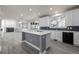 Open kitchen with an island, white cabinets, dark backsplash, and view into living area at 301 Amethyst Way, Superior, CO 80027