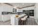 Well-lit kitchen features an island with seating, white cabinets, and black stainless appliances at 301 Amethyst Way, Superior, CO 80027