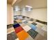 Spacious finished basement with multi-colored carpet tiles and bright lighting at 13024 E Alaska Pl, Aurora, CO 80012