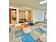 A finished basement features an open layout and unique colorful tiled flooring at 13024 E Alaska Pl, Aurora, CO 80012
