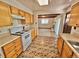 Well-maintained kitchen featuring tile floors and a breakfast bar overlooking the living room at 13024 E Alaska Pl, Aurora, CO 80012