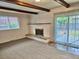 Cozy living room showcasing a brick fireplace, wood beam ceiling and access to the backyard at 13024 E Alaska Pl, Aurora, CO 80012