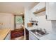 Compact kitchen featuring marble counters, stainless steel sink and faucet, and a window at 5995 E Iliff Ave # 106, Denver, CO 80222