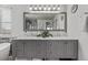 Bathroom featuring double sink vanity with gray cabinetry and stylish marble countertop and large mirror at 10707 Jordan Ct, Parker, CO 80134