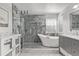 Bright bathroom with a freestanding tub, a glass-enclosed shower, and stylish tile work and gray vanity at 10707 Jordan Ct, Parker, CO 80134