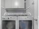 Well-lit laundry room with modern washer and dryer and cabinet storage at 10707 Jordan Ct, Parker, CO 80134