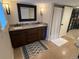 Bathroom featuring a double sink vanity with granite countertops, a shower, and neutral-colored walls at 2728 N Yates St, Denver, CO 80212
