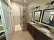 Bathroom with a walk-in shower and a double sink vanity with granite countertops and neutral walls at 2728 N Yates St, Denver, CO 80212
