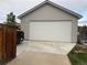 View of a large white garage door surrounded by green grass and a concrete driveway at 2728 N Yates St, Denver, CO 80212