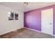 Bedroom with purple accent wall and neutral carpeting at 6825 E Martin Luther King Jr Blvd, Denver, CO 80207