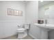 Stylish powder room with pedestal sink, toilet, and decorative wall paneling at 11027 Sunshimmer Cir, Parker, CO 80134