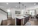 Modern kitchen island with a sink, dishwasher, and seating overlooking the dining area at 11027 Sunshimmer Cir, Parker, CO 80134