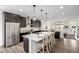 Open-concept kitchen with stainless steel refrigerator, kitchen island and dark wood cabinets at 11027 Sunshimmer Cir, Parker, CO 80134