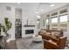 Bright living room boasts modern fireplace with white brick, hardwood floors, and ample natural light at 11027 Sunshimmer Cir, Parker, CO 80134
