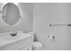 Bathroom featuring white sink vanity, toilet, round mirror and towel bars at 5927 S Kline St, Littleton, CO 80127