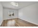 Bright, airy bedroom featuring wood floors, modern lighting, and a window overlooking the outdoors at 5927 S Kline St, Littleton, CO 80127