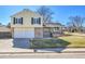 Charming two-story home with a two-car garage, brick accents, well-maintained lawn, and mature trees at 5927 S Kline St, Littleton, CO 80127