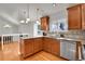 Kitchen featuring wooden cabinets, granite countertops, tile backsplash and stainless steel dishwasher at 5927 S Kline St, Littleton, CO 80127