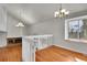 Bright living room featuring vaulted ceilings, hardwood floors, brick fireplace, and lots of natural light from a large window at 5927 S Kline St, Littleton, CO 80127