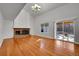 Spacious living room featuring vaulted ceilings, hardwood floors, brick fireplace, and sliding glass doors to outdoor area at 5927 S Kline St, Littleton, CO 80127