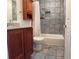 Bathroom with stone flooring, tiled shower, and a dark wood vanity at 935 N Pennsylvania St # 3, Denver, CO 80203