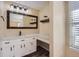 Updated bathroom with a vanity, floating shelves, and mirror at 11733 Elk Head Range Rd, Littleton, CO 80127