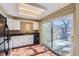 Kitchen with white cabinets, black appliances, and sliding glass door to patio at 11733 Elk Head Range Rd, Littleton, CO 80127