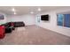 Finished basement with a sectional sofa and large TV at 11860 Sandcastle Ct, Parker, CO 80138