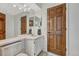 This bathroom includes double sinks, wood-toned doors and tiled flooring at 1737 Jules Ct, Highlands Ranch, CO 80126