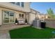 A cozy backyard featuring green grass, a small patio, and an air conditioning unit at 9676 W Chatfield Ave # B, Littleton, CO 80128