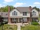 Charming two-story home with a brick facade, complemented by a well-manicured lawn and inviting front porch under a partly cloudy sky at 9676 W Chatfield Ave # B, Littleton, CO 80128