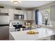 Modern kitchen features stainless appliances, quartz countertops, and ample natural light from the window at 9676 W Chatfield Ave # B, Littleton, CO 80128