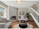 Bright living room with stone fireplace, plush seating, a staircase and hardwood floors at 9676 W Chatfield Ave # B, Littleton, CO 80128