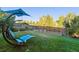 Inviting backyard featuring a comfortable lounge chair, lush lawn, and a charming wooden fence at 10961 Main Range Trl, Littleton, CO 80127