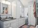 Well-lit bathroom featuring dual sinks, granite countertops, and modern cabinetry for storage at 10961 Main Range Trl, Littleton, CO 80127