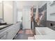 Inviting bathroom featuring granite counters, double sinks, sleek storage, and a modern shower at 10961 Main Range Trl, Littleton, CO 80127