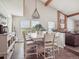 Bright dining area with vaulted ceilings, wood beams, and a modern chandelier at 10961 Main Range Trl, Littleton, CO 80127