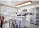 Bright eat-in kitchen with an island, white cabinetry, stainless appliances, and modern lighting at 10961 Main Range Trl, Littleton, CO 80127