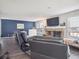 Comfortable living room with a brick fireplace, large windows, and dark blue accent wall at 10961 Main Range Trl, Littleton, CO 80127